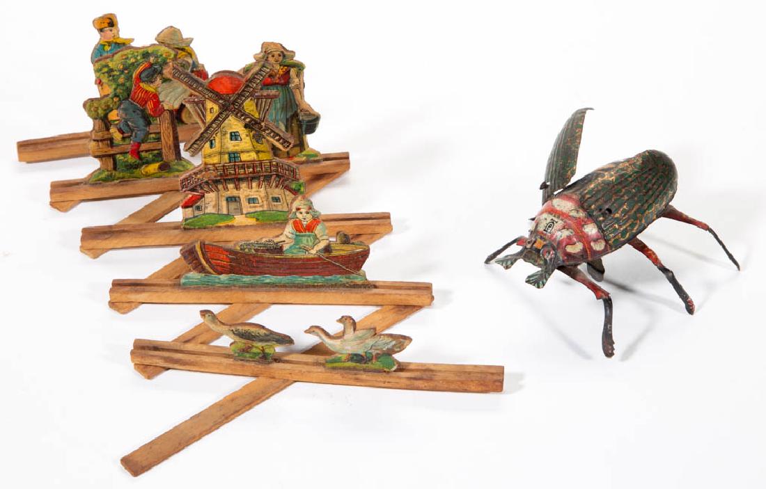 GERMAN LEHMANN WIND-UP LITHOGRAPHED TIN TOY: GERMAN LEHMANN WIND-UP LITHOGRAPHED TIN TOY, crawling beetle with flapping wings, lettering on body including 1895 patent date. Together with an expansion molded cardboard scene with lithographed Dutc
