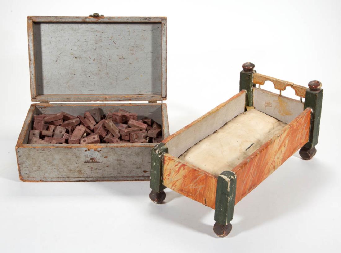 COUNTRY PAINTED CHILDREN'S TOYS, LOT OF TWO: COUNTRY PAINTED CHILDREN'S TOYS, LOT OF TWO, comprising a paint-decorated doll bed and a gray-painted box containing an uncounted number of clay tile building blocks. Late 19th/first half 20th century