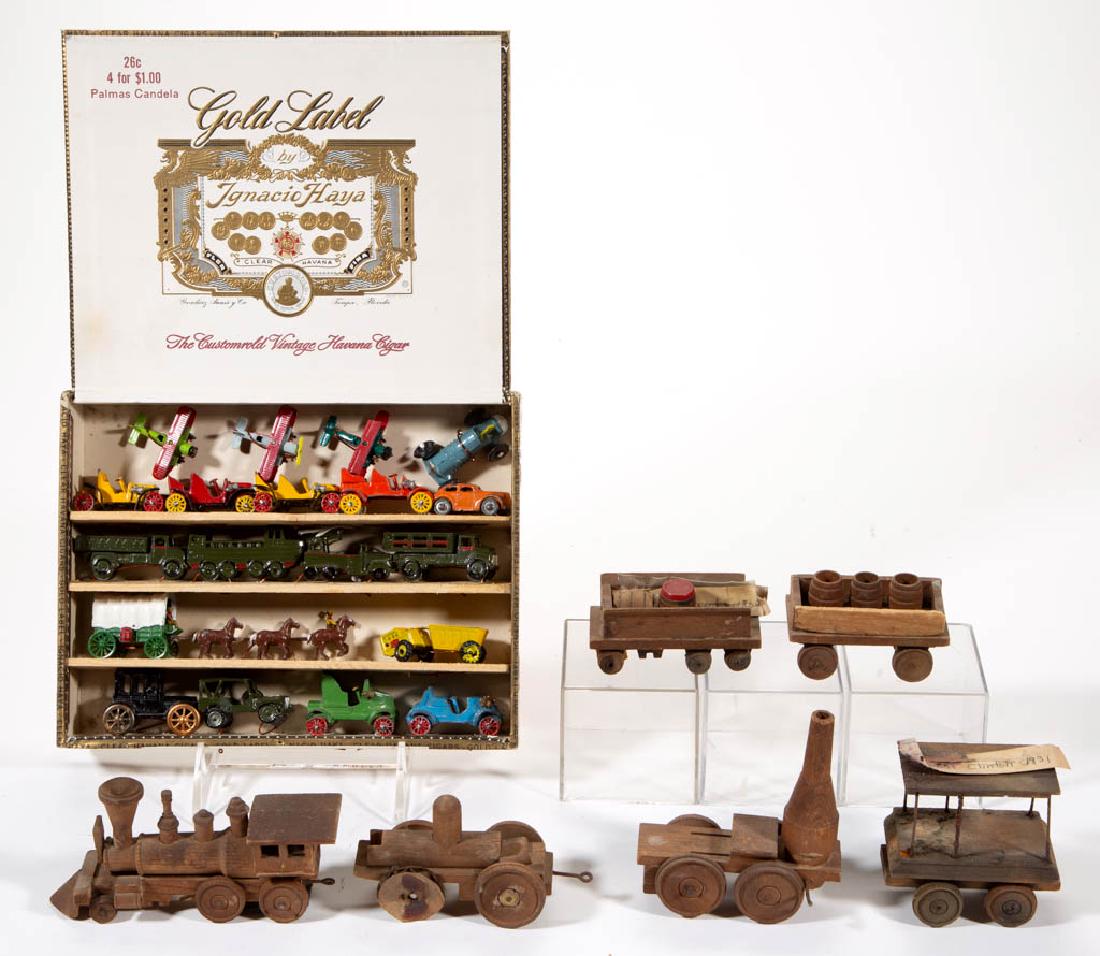 VINTAGE WOOD / METAL TOYS, LOT OF 25: VINTAGE WOOD / METAL TOYS, LOT OF 25, comprising a six-piece wooden miniature train and 19 metal vehicles including airplanes and army trucks, mounted in a cigar box. 20th century. 3/4" to 3 7/8" HOA.