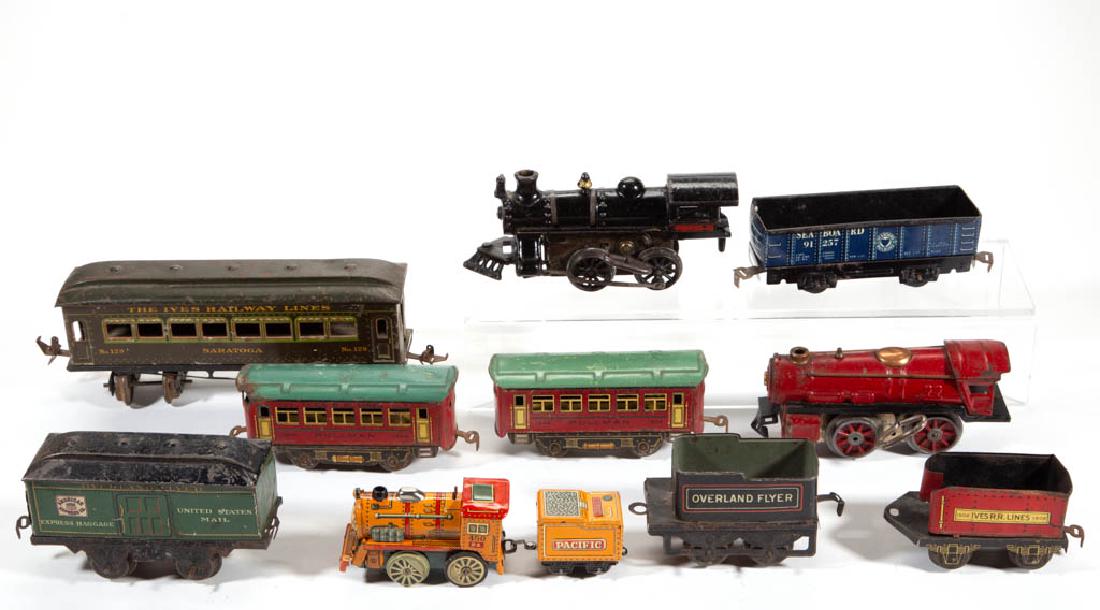 ASSORTED VINTAGE TRAIN TOYS, LOT OF 11: ASSORTED VINTAGE TRAIN TOYS, LOT OF 11, including a cast-iron clockwork locomotive, a pressed-steel clockwork locomotive, and several tin Ives cars. First half 20th century. 4 1/4" to 9 1/2" LOA. As-f
