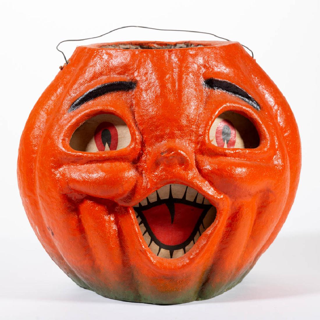 VINTAGE HALLOWEEN PAPIER-MACHE JACK-O-LANTERN: VINTAGE HALLOWEEN PAPIER-MACHE JACK-O-LANTERN, painted finish, having original printed paper insert, wire hanging handle. First half 20th century. 7 1/4" H rim. Expected wear, scattered flakes to pain
