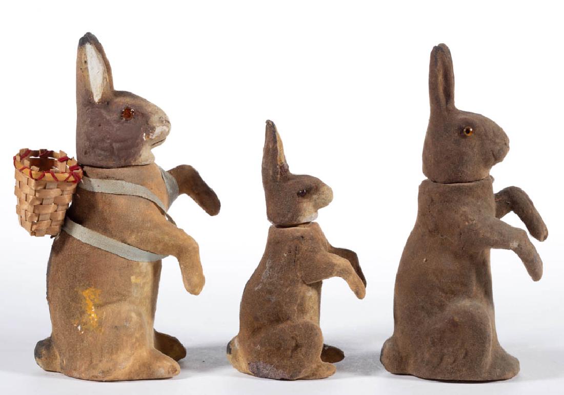 GERMAN COMPOSITION / PAPIER-MACHE RABBIT CANDY: GERMAN COMPOSITION / PAPIER-MACHE RABBIT CANDY CONTAINERS, LOT OF THREE, each posed in an upright sitting position, having polychrome finish and removable head, one example with basket on its back. Un