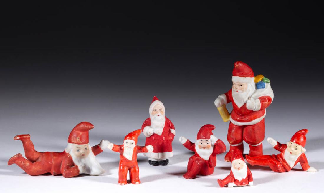 GERMAN SANTA CLAUS BISQUE MINIATURE FIGURES, LOT OF: GERMAN SANTA CLAUS BISQUE MINIATURE FIGURES, LOT OF SEVEN, including one example carrying a bag and lantern. Five pieces with "Germany" mark. First half 20th century. 1 1/8" to 3 3/4" HOA. Each with e