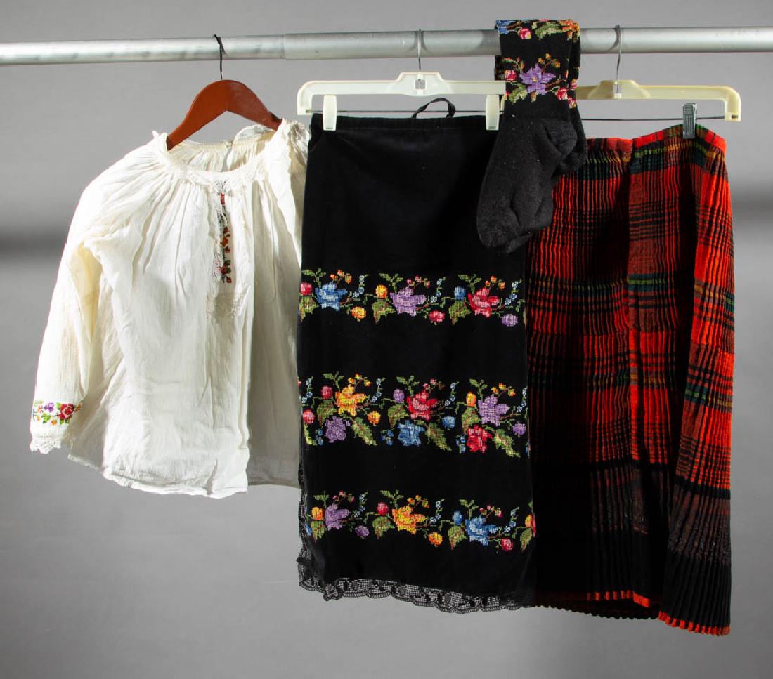 EUROPEAN FOLK / TRADITIONAL COSTUME ARTICLES, LOT OF 11: EUROPEAN FOLK / TRADITIONAL COSTUME ARTICLES, LOT OF 11, comprising two shirts, a vest and skirt set, two aprons, a scarf, a pleated skirt, a sash, and two pairs of stockings. 20th century. One skirt:
