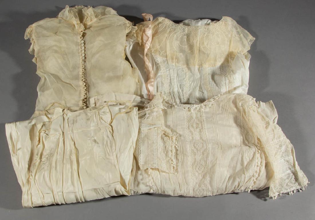 ANTIQUE / VINTAGE WHITE DRESSES, LOT OF THREE: ANTIQUE / VINTAGE WHITE DRESSES, LOT OF THREE, comprising an off-white sheer wedding/formal example with buttons down the back and a train, an example having lace and embroidered designs, and an examp