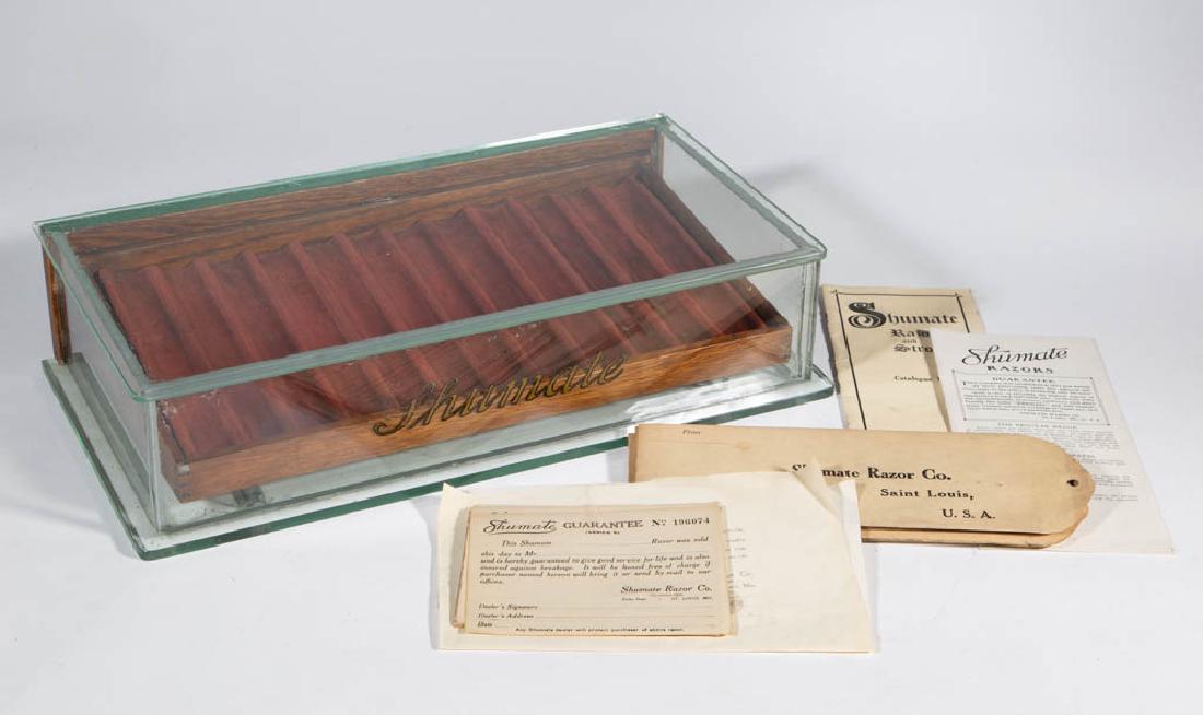 SHUMATE RAZOR CO. COUNTRY STORE COUNTER-TOP DISPLAY /: SHUMATE RAZOR CO. COUNTRY STORE COUNTER-TOP DISPLAY / SHOWCASE, glass case, front with gilt-lettering "Shumate", concealing an oak tray with velvet-lined pockets for 12 straight razors, with brass pla