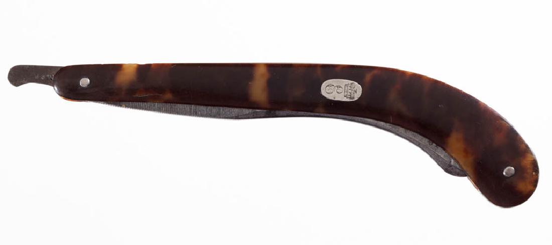 ENGLISH SHELL-HANDLED STRAIGHT RAZOR: ENGLISH SHELL-HANDLED STRAIGHT RAZOR, gunstock form, inlaid escutcheon plate with an engraved Crown and "E" on handle, "AMMER" marked on the tail. First quarter 19th century. 6 1/4" L handle. Very goo