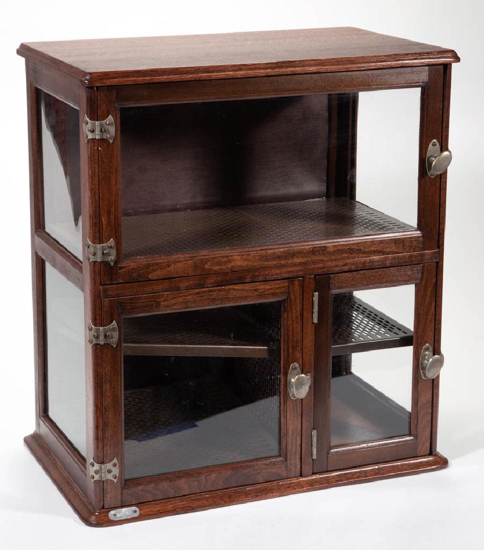 AMERICAN OAK BARBER SHOP SHAVING CABINET: AMERICAN OAK BARBER SHOP SHAVING CABINET, having three doors, interior with metal sanitary trays, with a tag in the left hand corner stamped "30763". 20th century. 21 3/4" H, 19 1/4" W, 11 1/2" D.Very