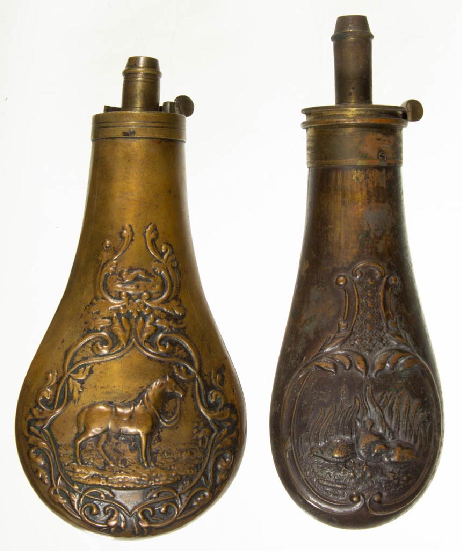 ASSORTED BRASS POWDER FLASKS, LOT OF TWO: ASSORTED BRASS POWDER FLASKS, LOT OF TWO, with embossed decoration of a horse and pheasants stamped "Am. Flask & Cap Co". 19th century. 7" LOA. Very good overall condition, with expected usage wear. P