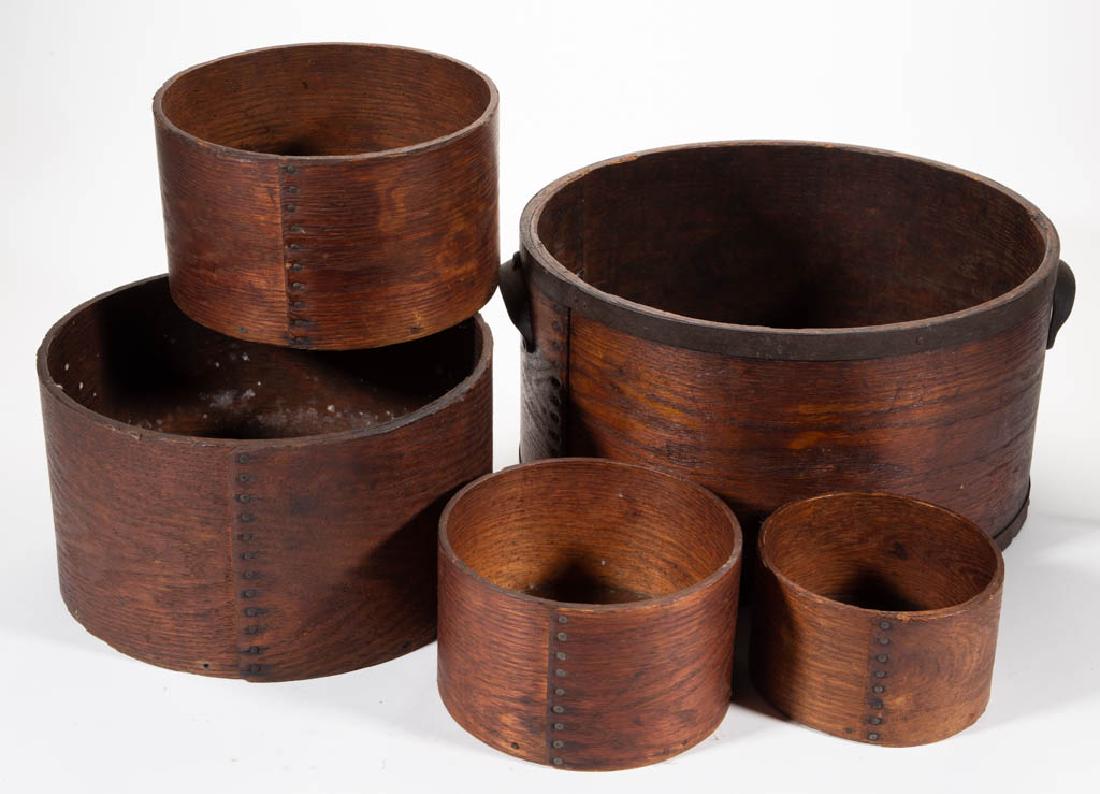 DANIEL CRAGIN WOODEN FIVE-PIECED GRADUATED DRY MEASURE: DANIEL CRAGIN WOODEN FIVE-PIECED GRADUATED DRY MEASURE SET, each circular form of nailed lap construction with pinned bottom board, largest having applied iron reinforcement bands and handles. Each wi