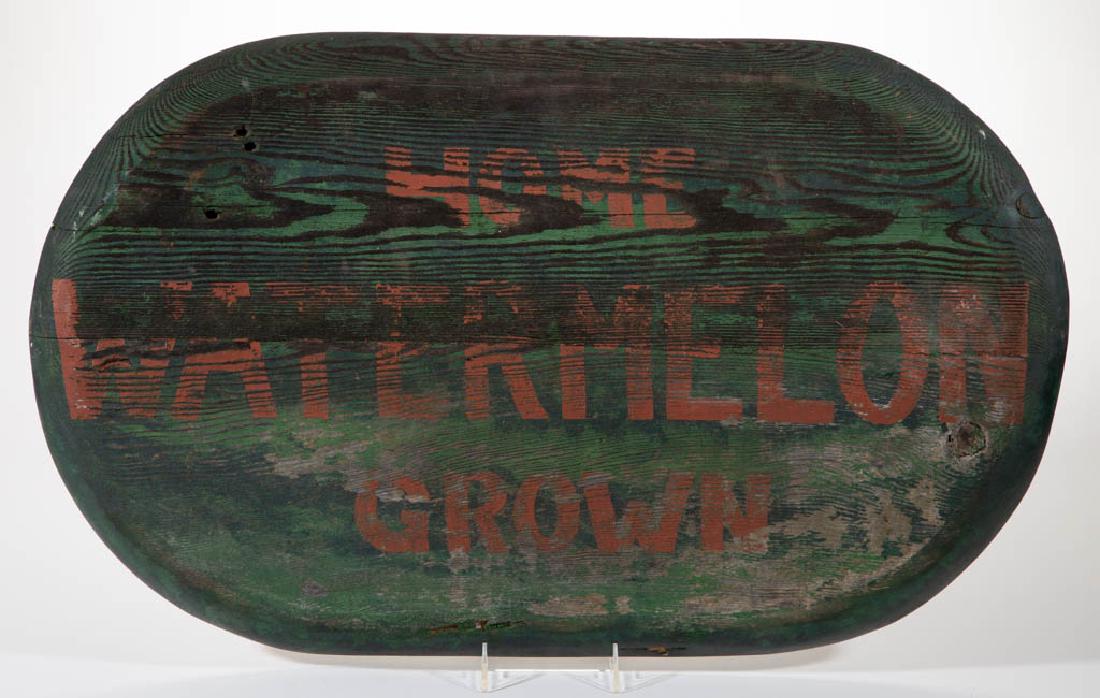 AMERICAN FOLK ART PAINTED PINE TRADE SIGN: AMERICAN FOLK ART PAINTED PINE TRADE SIGN, elliptical form with red lettering against a green ground. First half 20th century. 17 3/4" x 29".Fair overall condition with expected cracks and weathering.