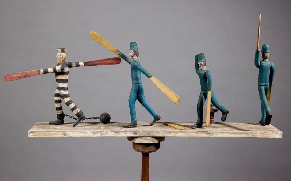 FOLK ART CARVED AND PAINTED WHIRLIGIG: FOLK ART CARVED AND PAINTED WHIRLIGIG, whimsical depiction of three policemen chasing an escaped convict, signed, titled, and inscribed "J. Neale / Woolwich, Maine / Jail Break" to underside, mounted 