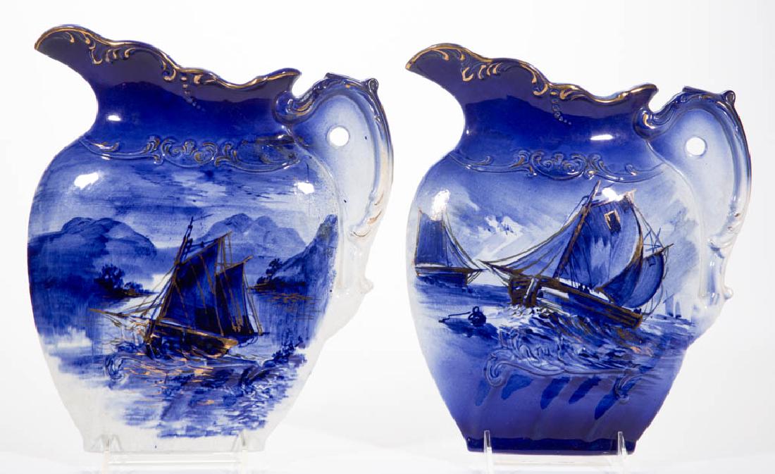 ENGLISH FLOW BLUE IRONSTONE CERAMIC WALL PLAQUES: ENGLISH FLOW BLUE IRONSTONE CERAMIC WALL PLAQUES TWO-PIECE SET, hand-painted pitcher-shaped molded plaques, having sailboat patterns with gilded decoration. Unmarked. Second half 19th century. 11 3/4"