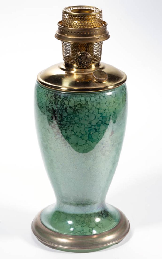 ALADDIN NO. 1243 VENETIAN ART-CRAFT GLASS KEROSENE: ALADDIN NO. 1243 VENETIAN ART-CRAFT GLASS KEROSENE SHORT VASE LAMP, mottled green, color fused on the interior, wide silver trim to the edge of the foot. Fitted with a brass drop-in font and a Model 1