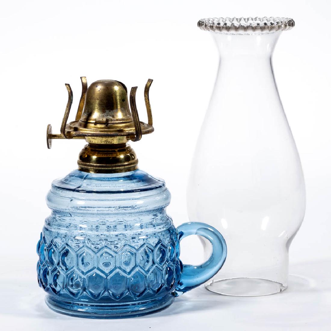COLORED GLASS KEROSENE FINGER LAMP: COLORED GLASS KEROSENE FINGER LAMP, blue, barrel form with honeycomb pattern, ringed neck, applied blue handle, period No. 1 collar. Fitted with a period No. 0 slip burner and colorless chimney. Fourt