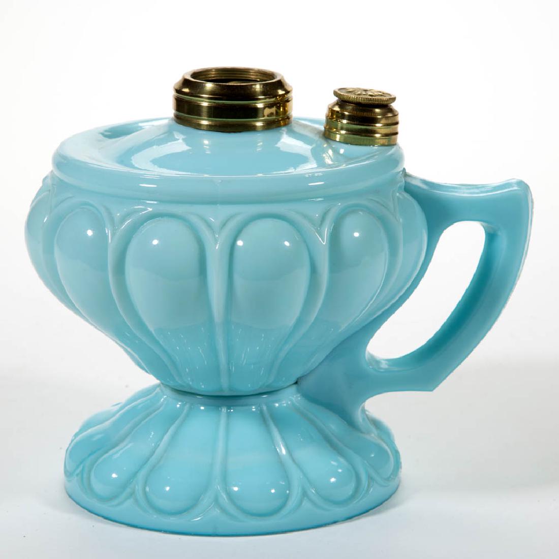 LOWELL LOOP KEROSENE FOOTED FINGER LAMP: LOWELL LOOP KEROSENE FOOTED FINGER LAMP, opaque light blue, molded handle, brass side refill feature, No. 2 Taplin-Brown collar. Fourth quarter 19th century. 6" H to top of collar, 5" D foot. Undamage