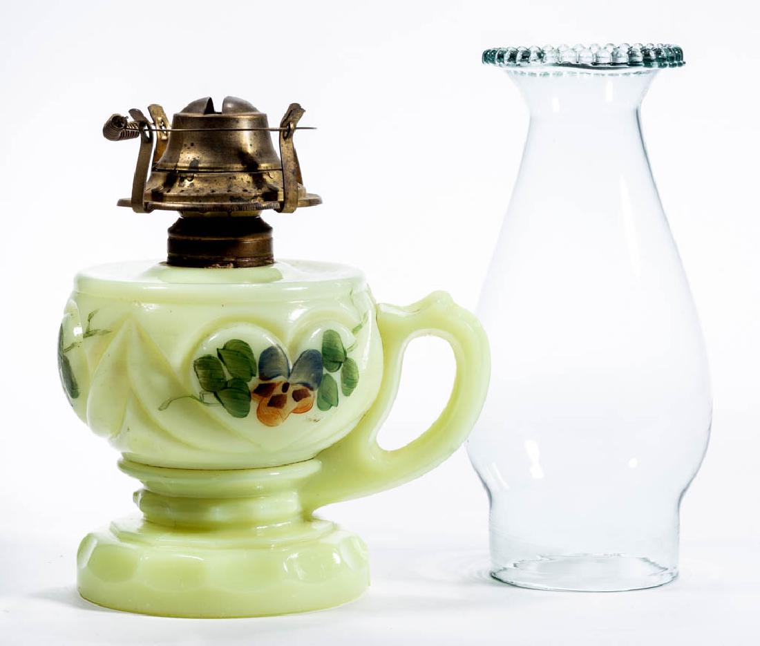 HEART KEROSENE FOOTED FINGER LAMP: HEART KEROSENE FOOTED FINGER LAMP, custard (reacts under black light) with polychrome-enamel decoration, No. 1 Taplin-Brown collar. Fitted with a period No. 1 slip burner and slip chimney with a beade