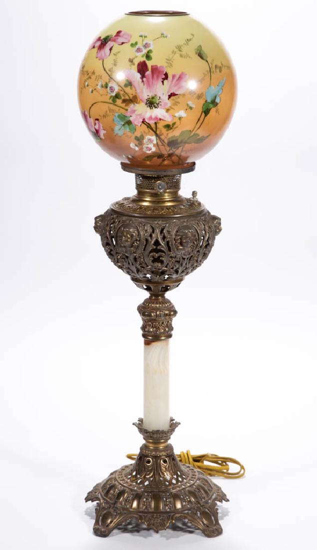 VICTORIAN BRASS AND CAST-METAL BANQUET LAMP: VICTORIAN BRASS AND CAST-METAL BANQUET LAMP, opaque white ball-form shade with light to dark salmon ground, polychrome floral decoration, brass heat ring, cast-metal globular-form font cast-iron base 