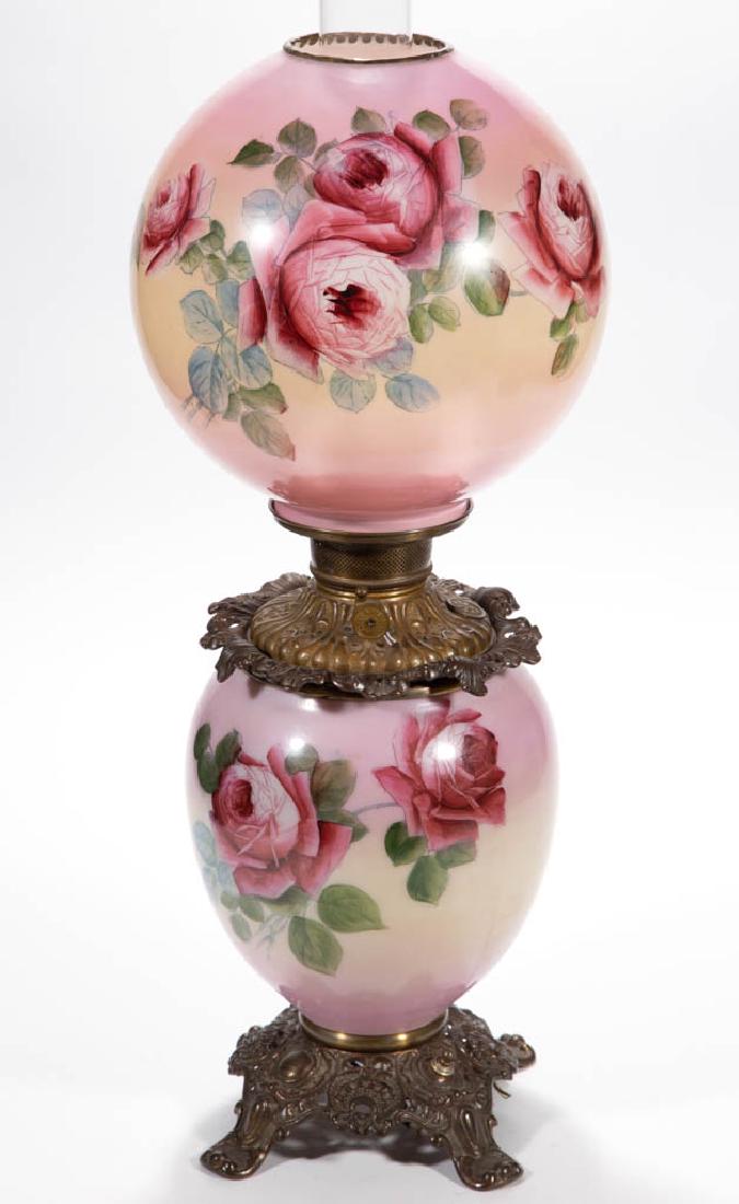 FOSTORIA ENAMEL-DECORATED PARLOR / GONE WITH THE WIND: FOSTORIA ENAMEL-DECORATED PARLOR / GONE WITH THE WIND LAMP, opaque white with pink ground and polychrome rose stencil decoration, matching decorated ball-form shade with brass heat ring; elongated-for