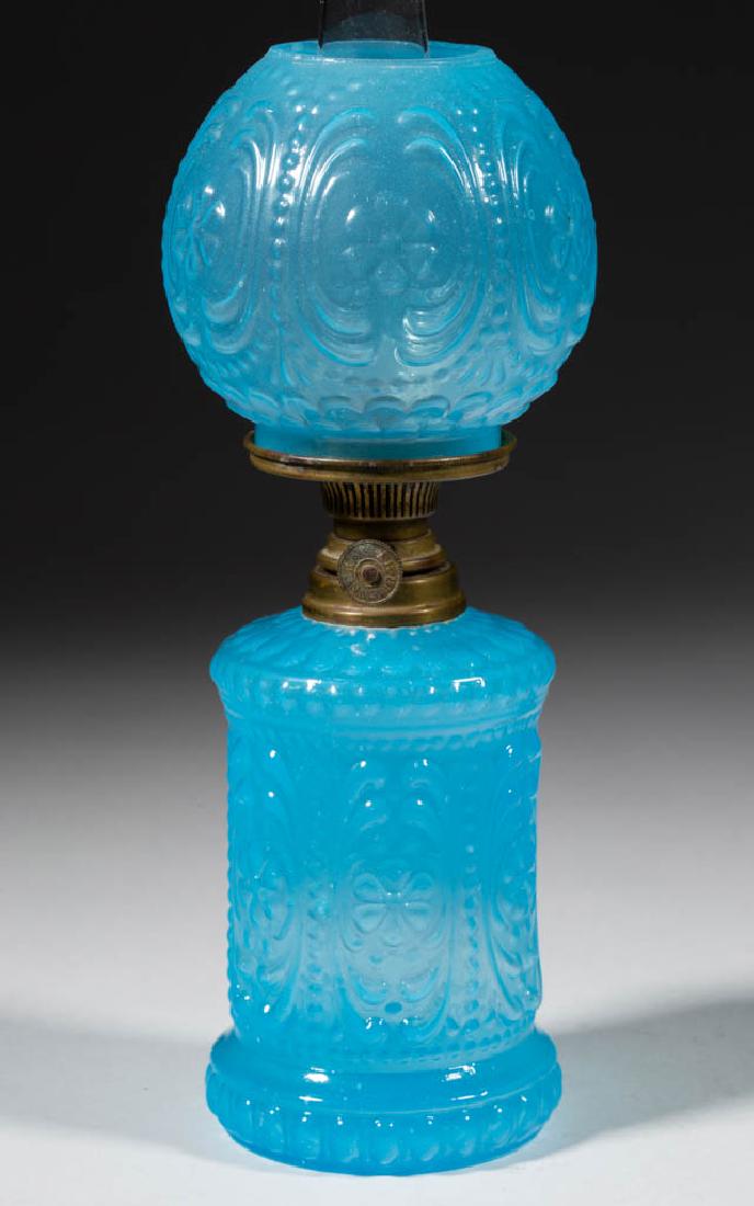 EMBOSSED FLORAL AND SCROLL MINIATURE LAMP: EMBOSSED FLORAL AND SCROLL MINIATURE LAMP, translucent blue opaline, cylinder-form font with slightly concave banded medial, matching pattern ball-form shade, period collar. Fitted with a period Spar