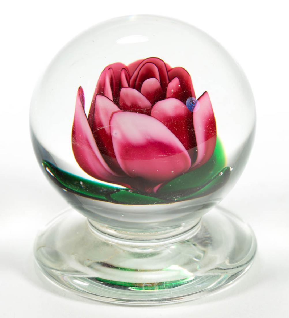 CHARLES KAZIUN JR. STUDIO ART GLASS LAMPWORK: CHARLES KAZIUN JR. STUDIO ART GLASS LAMPWORK PAPERWEIGHT, colorless, applied foot, depicting a fuchsia Millville-style flower with four green leaves, signature cane to the backside. Massachusetts. Sec