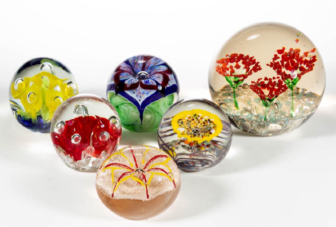 ASSORTED FLORAL GLASS PAPERWEIGHTS, LOT OF SIX: ASSORTED FLORAL GLASS PAPERWEIGHTS, LOT OF SIX, colorless, including a three-flower frit, a yellow five-flower, and a polychrome-flower with swirled green ground. Various makers. 20th century. 2 1/2" 