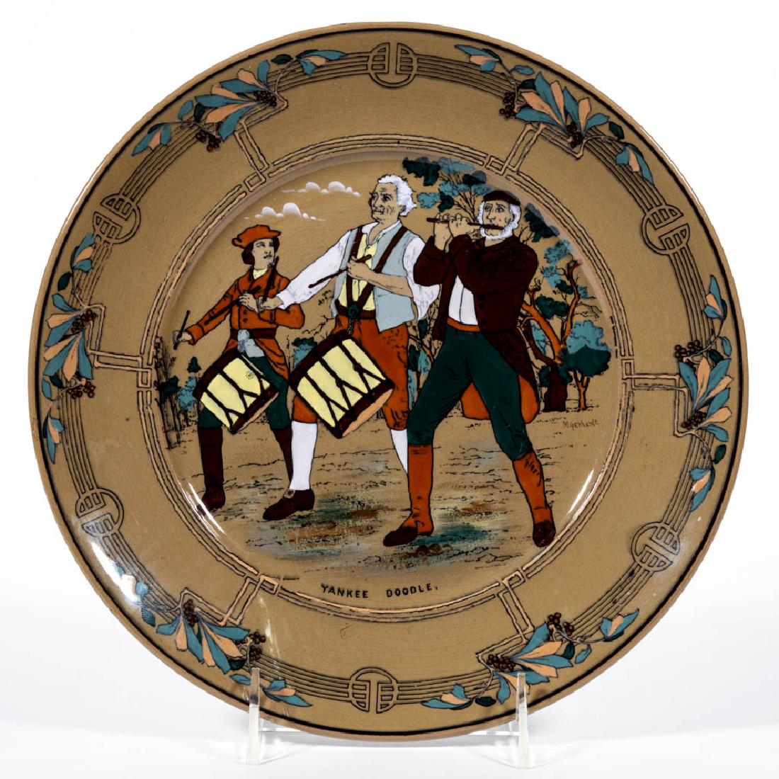 AMERICAN BUFFALO POTTERY DELDARE "YANKEE DOODLE": AMERICAN BUFFALO POTTERY DELDARE "YANKEE DOODLE" CERAMIC PLATE, with two marching drummers and a fife player. Signed "M.[abel] Gerhardt." on right side with hand-brushed mark "Buffalo Pottery / 1915" 