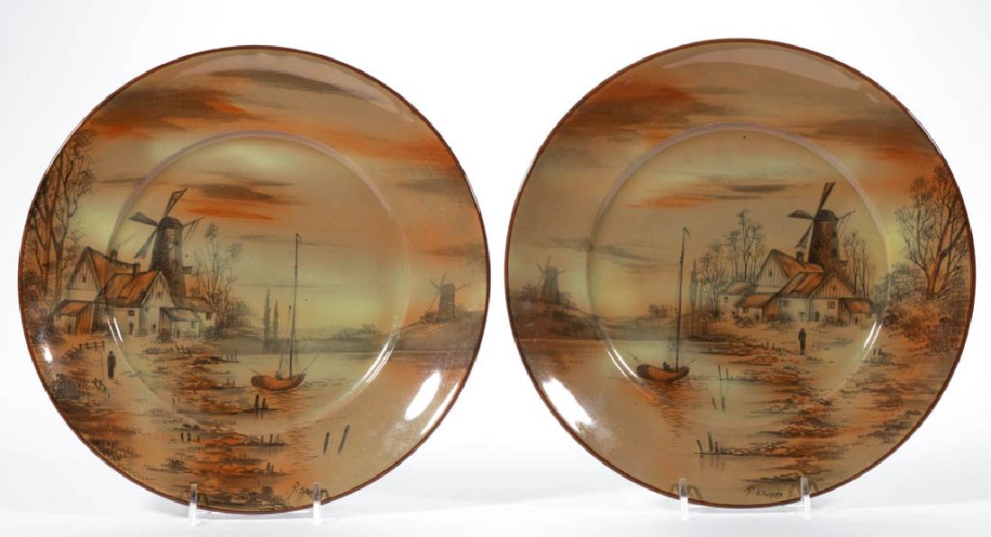 AMERICAN BUFFALO POTTERY ABINO WARE RALPH STUART: AMERICAN BUFFALO POTTERY ABINO WARE RALPH STUART CERAMIC PLATES, LOT OF TWO, consisting of a matching pair having mirrored rust-colored hand-painted images of windmills and boats, signed "R.[alph] Stu