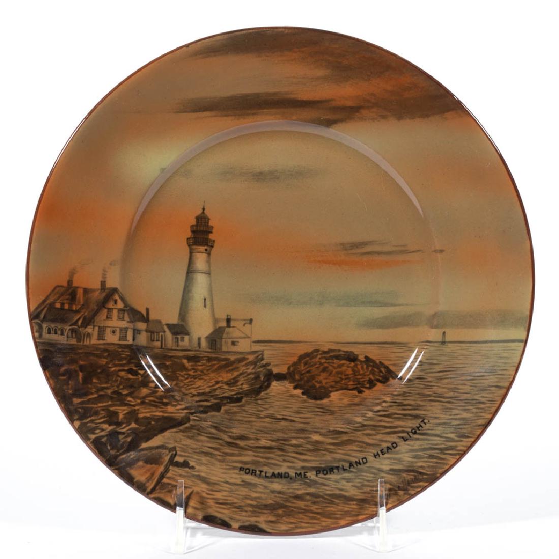 AMERICAN BUFFALO POTTERY ABINO WARE "PORTLAND, ME.": AMERICAN BUFFALO POTTERY ABINO WARE "PORTLAND, ME." CERAMIC PLATE, having a rust-colored lighthouse and ocean scene, with "PORTLAND, ME. PORTLAND HEAD LIGHT." printed at the bottom and signed "C. Harr