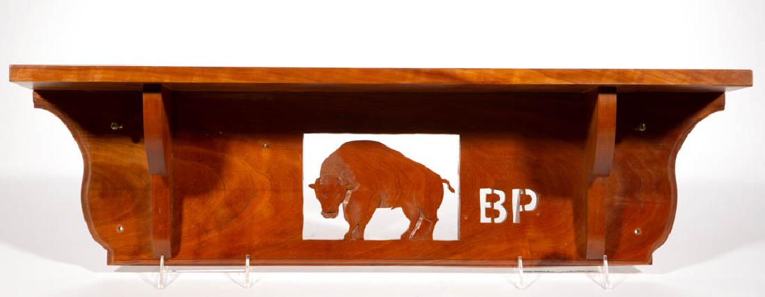 AMERICAN BUFFALO POTTERY-ASSOCIATED CHERRY SHELF: AMERICAN BUFFALO POTTERY-ASSOCIATED CHERRY SHELF, having central cut-out buffalo image with cut-out "B P" on right side with 19 1/4" carved slot on top. Fourth quarter 20th century. 8 1/4" H x 30" W.G
