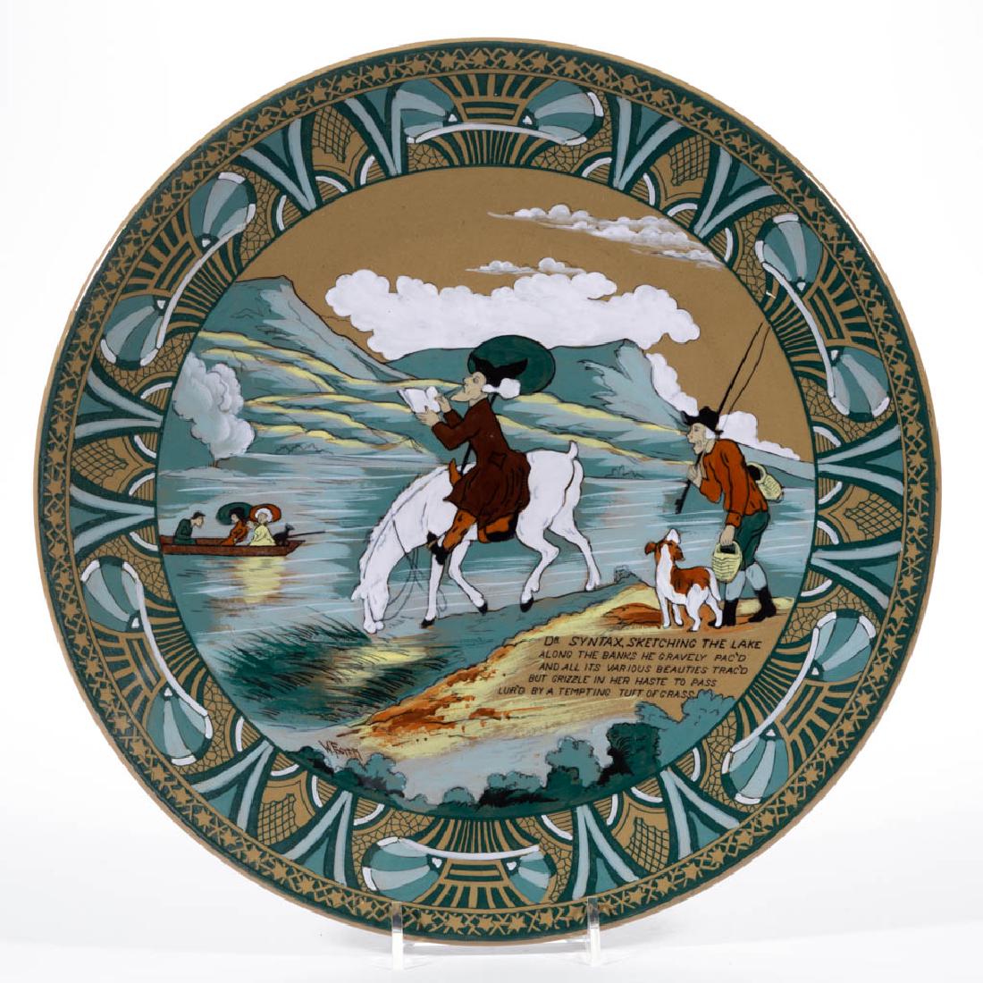 AMERICAN BUFFALO POTTERY EMERALD DELDARE DR. SYNTAX: AMERICAN BUFFALO POTTERY EMERALD DELDARE DR. SYNTAX CERAMIC PLAQUE, circular-shaped with scene "Dr. Syntax Sketching the Lake" depicting a gentleman drawing while astride a horse, with fisherman and d