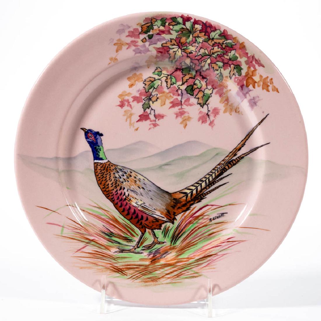 AMERICAN BUFFALO POTTERY RALPH STUART ROUGE WARE: AMERICAN BUFFALO POTTERY RALPH STUART ROUGE WARE CERAMIC PLATE, having black transfer design of a ring-necked pheasant standing under autumn leaves with pleasant polychrome hand-painted decoration on