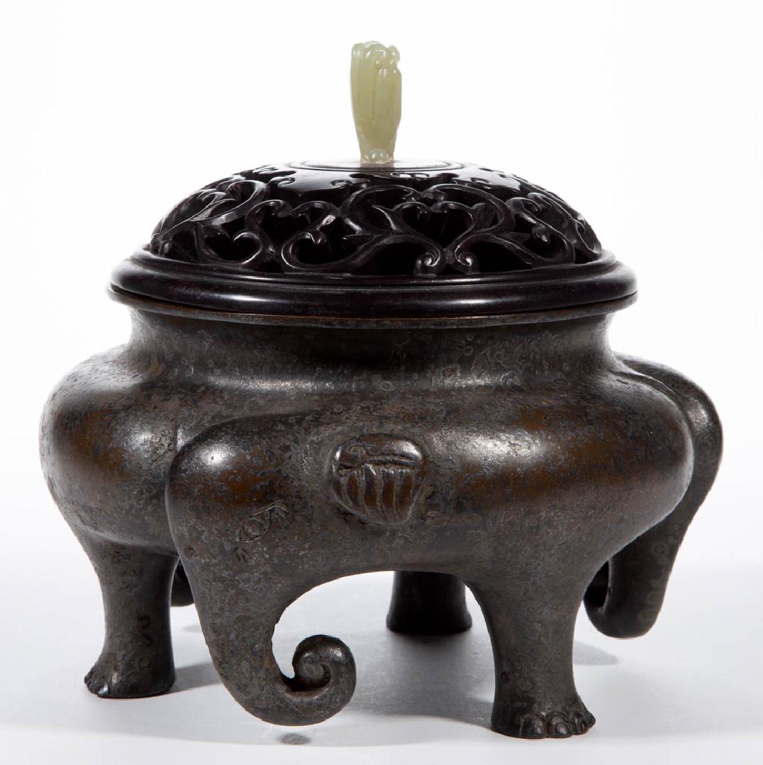 CHINESE FIGURAL BRONZE CENSER: CHINESE FIGURAL BRONZE CENSER, cast figural form featuring three elephant heads with curled trunks and three feet, topped by a pierced probably rosewood cover with carved nephrite/jade finial. Pseudo 