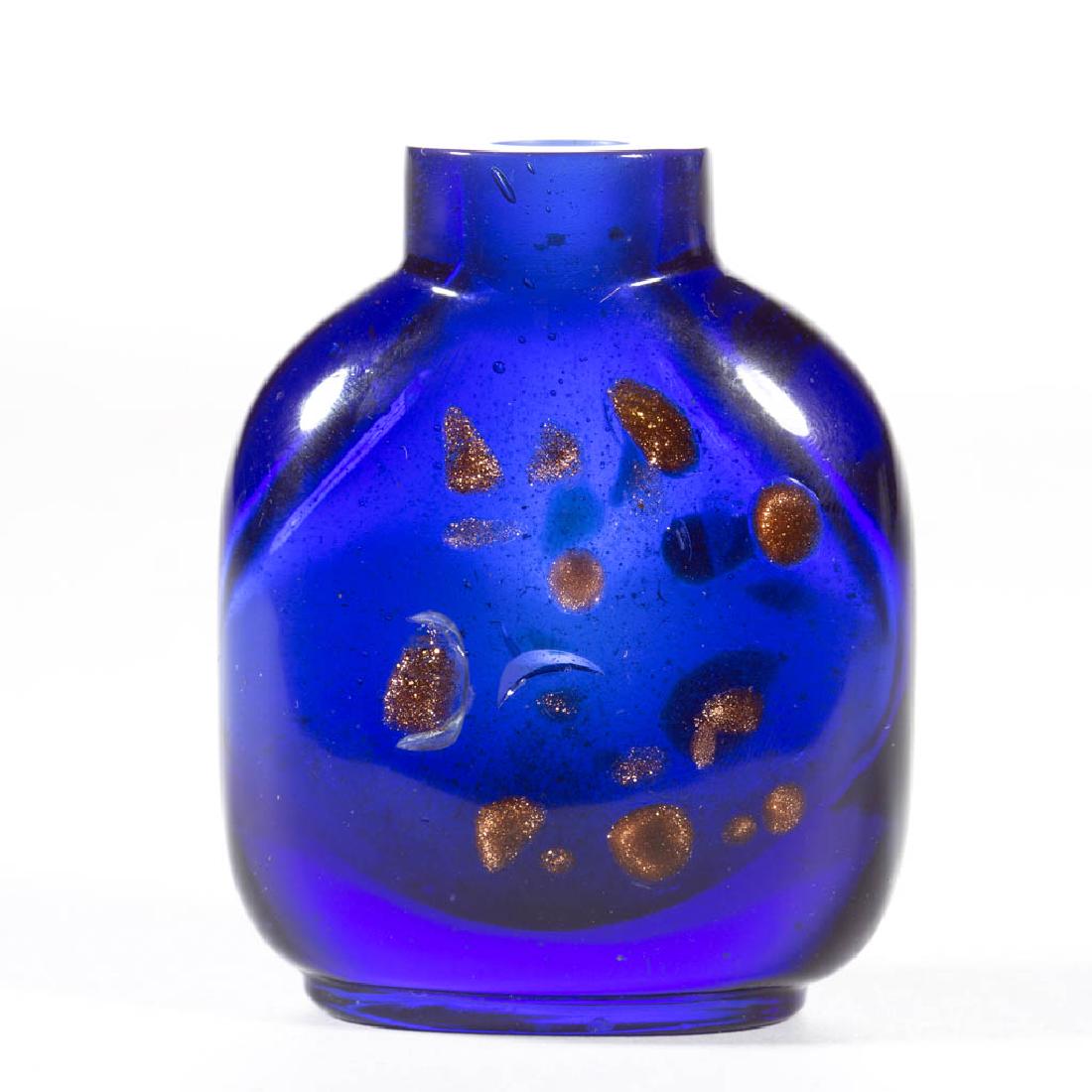 CHINESE COBALT GLASS SNUFF BOTTLE: CHINESE COBALT GLASS SNUFF BOTTLE, having flake inclusions of goldstone/aventurine. Missing cap. Probably 19th century. 2 3/8" H.Having crescent shaped bruises and/or air bubbles. Provenance: From the