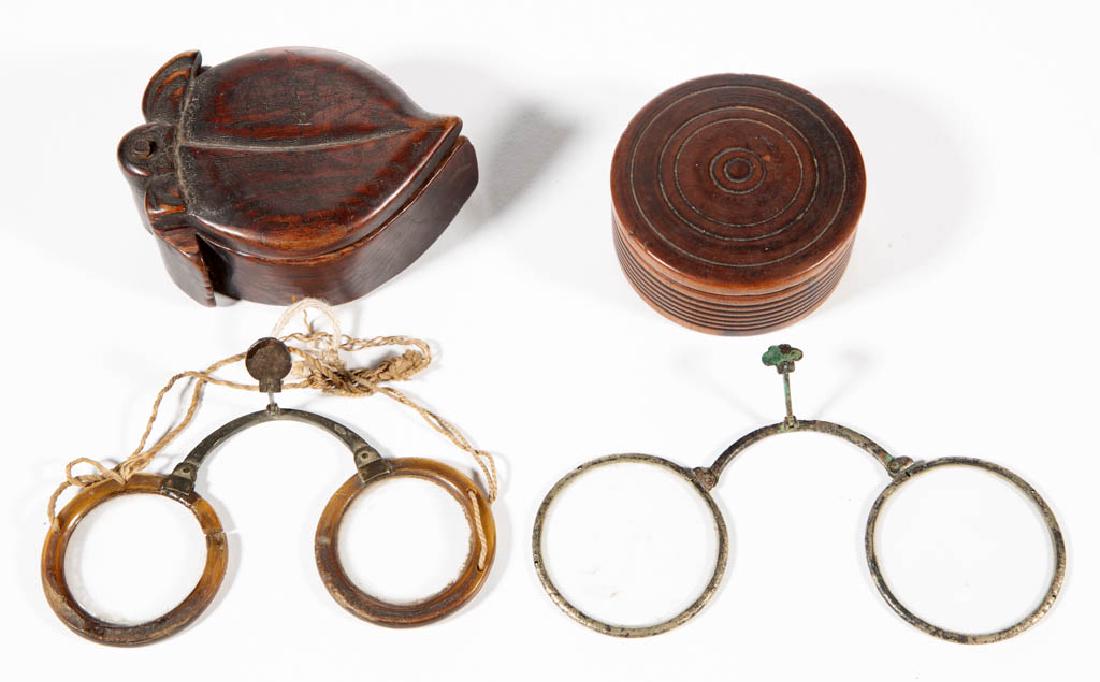 CHINESE EYEGLASSES AND CASES, LOT OF TWO: CHINESE EYEGLASSES AND CASES, LOT OF TWO, each with wooden case, one with concentric circle form and the other fruit-shaped, and one metal rimmed and one bone folding glasses. Cases retain an old surf