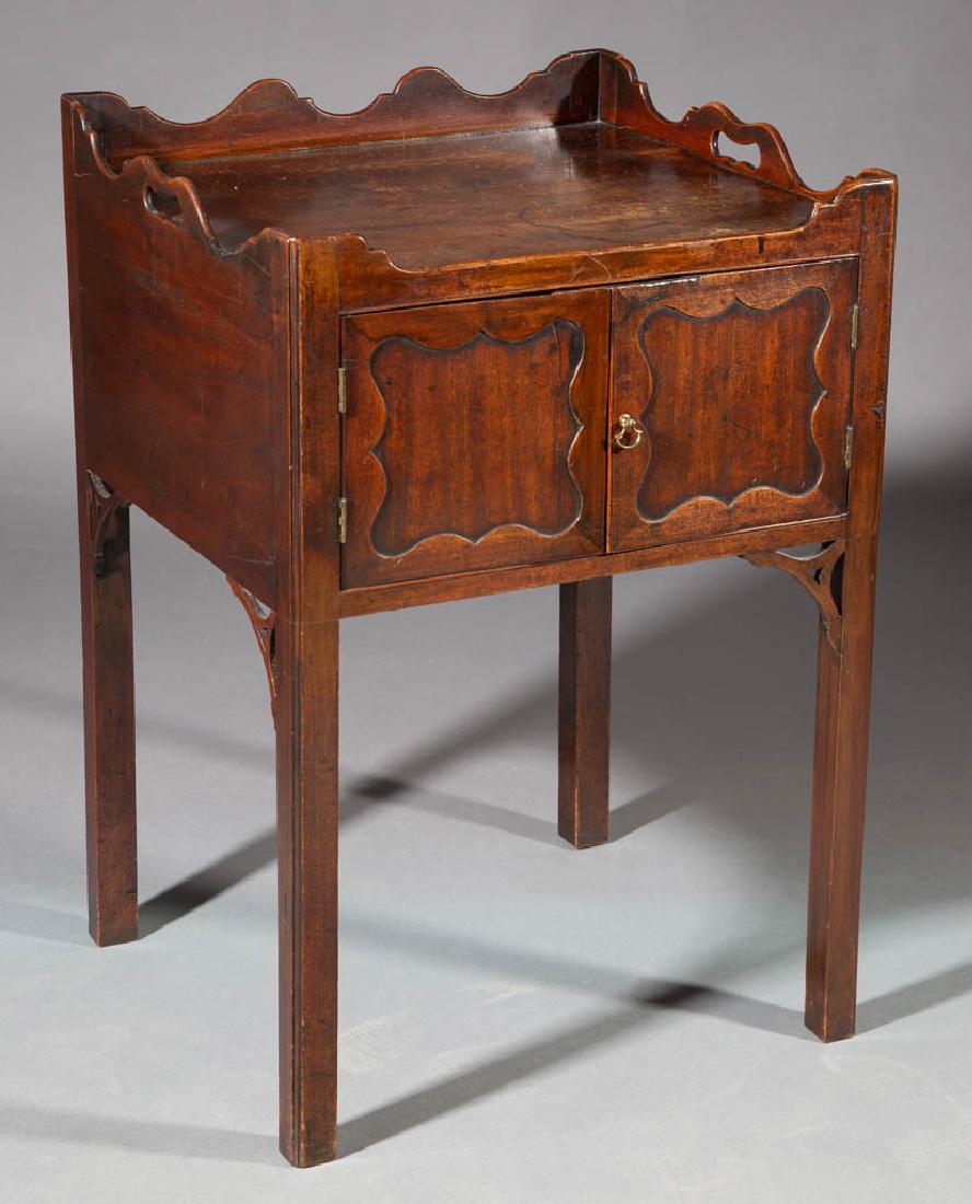 GEORGIAN MAHOGANY COMMODE: GEORGIAN MAHOGANY COMMODE, serpentine gallery above two hinged-doors with recessed panels, underside with fret work, raised on square legs. Oak secondary wood. Retains an old surface with warm color. 