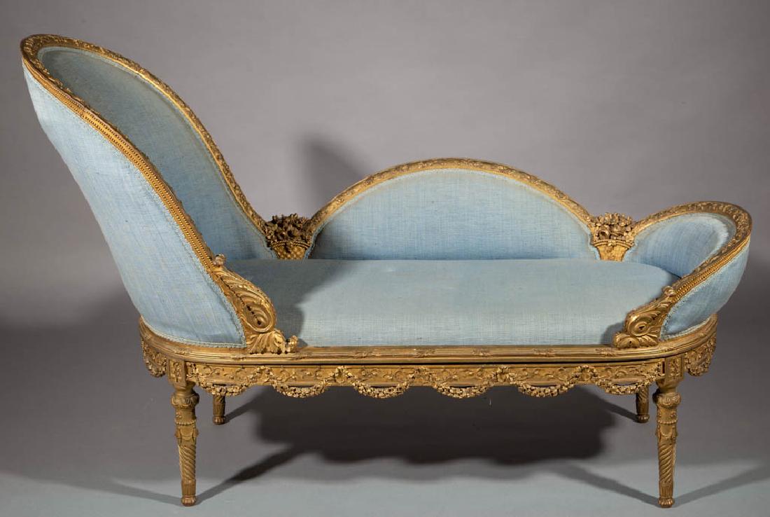 FRENCH LOUIS XV-STYLE CARVED GILTWOOD CHAISE LOUNGE: FRENCH LOUIS XV-STYLE CARVED GILTWOOD CHAISE LOUNGE, three-piece construction, featuring carved flower baskets, floral swags, and other foliate devices, retains an old blue upholstery. Oak and other s