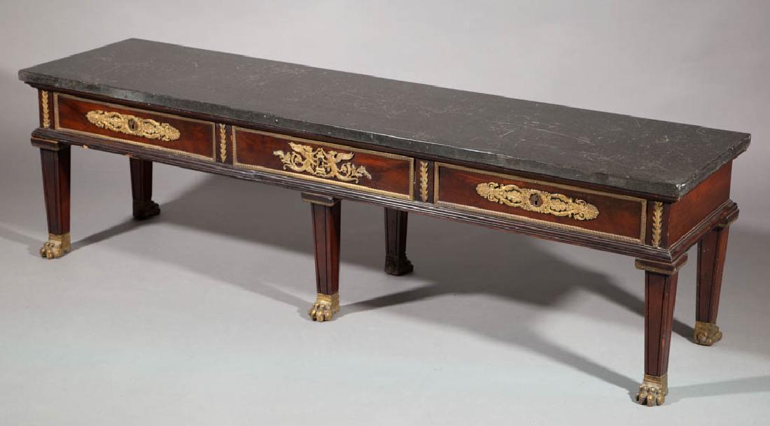 FRENCH MARBLE-TOP COFFEE TABLE: FRENCH MARBLE-TOP COFFEE TABLE, black marble, three-drawers with applied gilt-decoration, middle-drawer with mermaids, raised on six legs terminating in brass paw feet. Retains an old surface with war