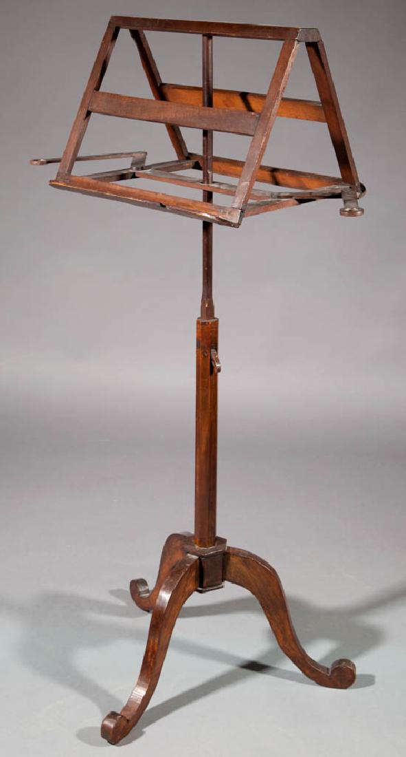 AMERICAN OR BRITISH MAHOGANY MUSIC LECTERN / BOOK STAND: AMERICAN OR BRITISH MAHOGANY MUSIC LECTERN / BOOK STAND, with two elongated arms possibly to hold a lighting device, stand adjusted by a trammel system, raised on a tripodal base. Retains an old refin