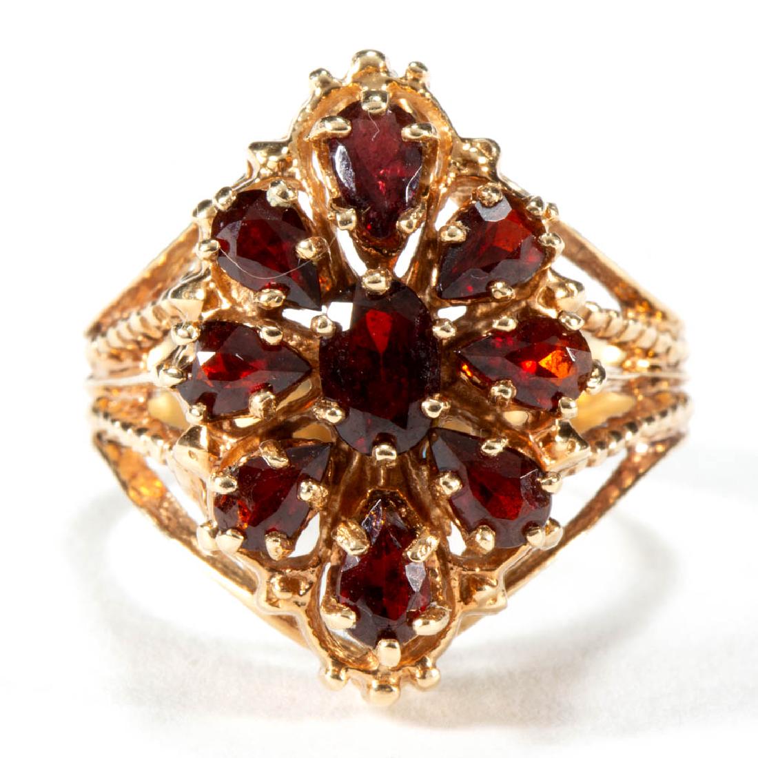 VINTAGE 10K YELLOW GOLD AND GARNET LADY'S RING: VINTAGE 10K YELLOW GOLD AND GARNET LADY'S RING, cluster form having oval-cut center garnet, measuring approximately 4.0 mm x 6.0 mm, surrounded by eight pear-cut garnets, each measuring approximately 