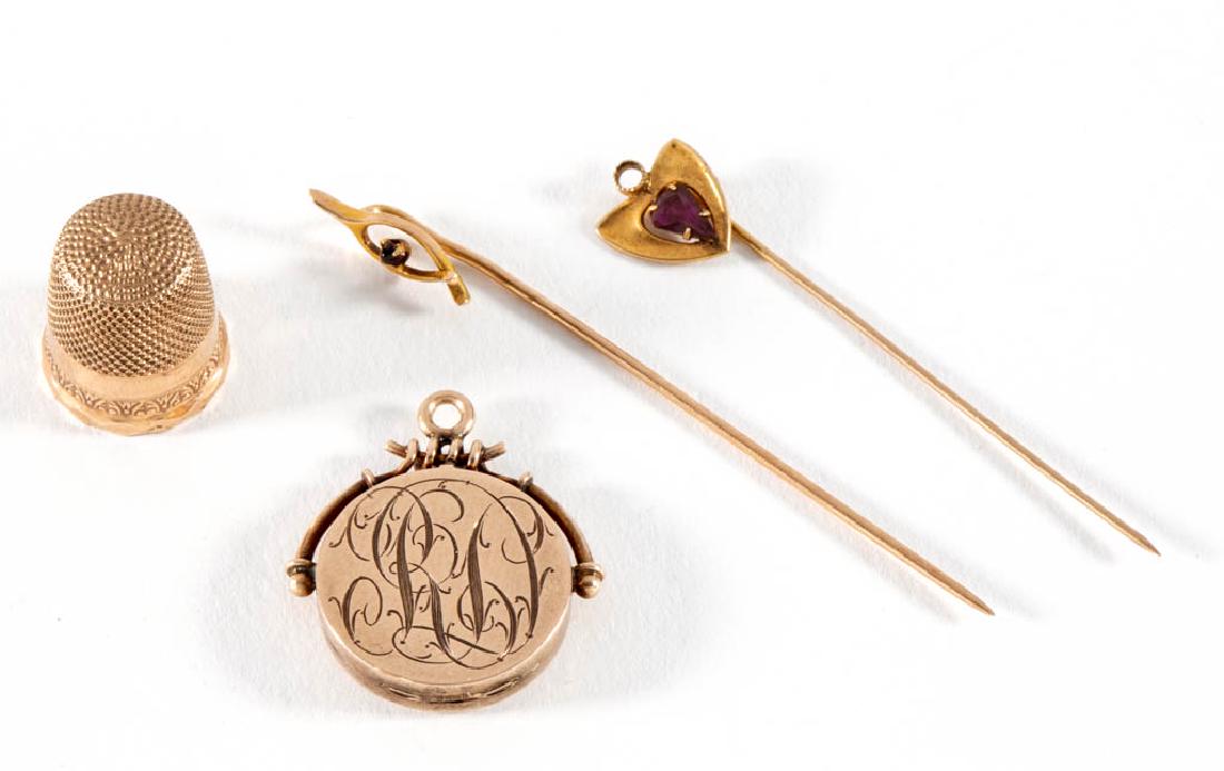 ANTIQUE / VINTAGE 10K YELLOW GOLD JEWELRY AND THIMBLE,: ANTIQUE / VINTAGE 10K YELLOW GOLD JEWELRY AND THIMBLE, LOT OF FOUR, comprising a locket with a round-cut melee diamond to one side and engraved "RD" initials to the other side, two stick pins with gla