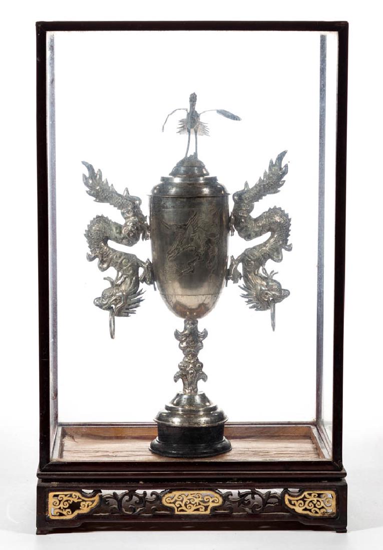 ASIAN SILVER-PLATED COVERED GOBLET / TROPHY CUP: ASIAN SILVER-PLATED COVERED GOBLET / TROPHY CUP, well with embossed bird and tree design, two removable decorative handles of dragon figures, topped by a cover with a brass-toned Fenghuang-type bird f