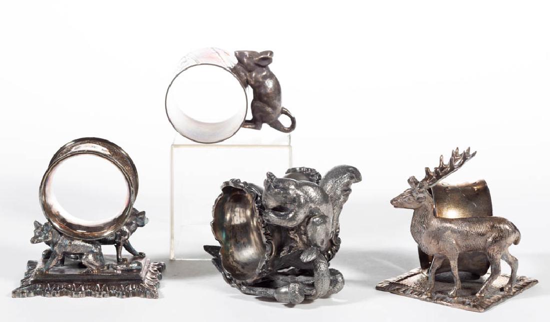 ASSORTED ANIMAL FIGURAL SILVER-PLATED NAPKIN RINGS, LOT: ASSORTED ANIMAL FIGURAL SILVER-PLATED NAPKIN RINGS, LOT OF FOUR, comprising a "66" fox/wolf example by Middletown Plate Co. with engraved initials, a "81" stag/buck example with worn maker's mark, an