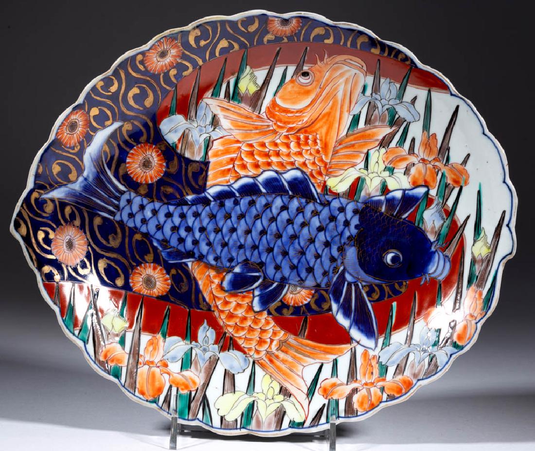 JAPANESE MEIJI-PERIOD IMARI FISH PORCELAIN DISH: JAPANESE MEIJI-PERIOD IMARI FISH PORCELAIN DISH, having an oval shape with scalloped rim and bright polychrome hand-painted bas-relief image of two swimming carp with irises and gilt decoration, and u