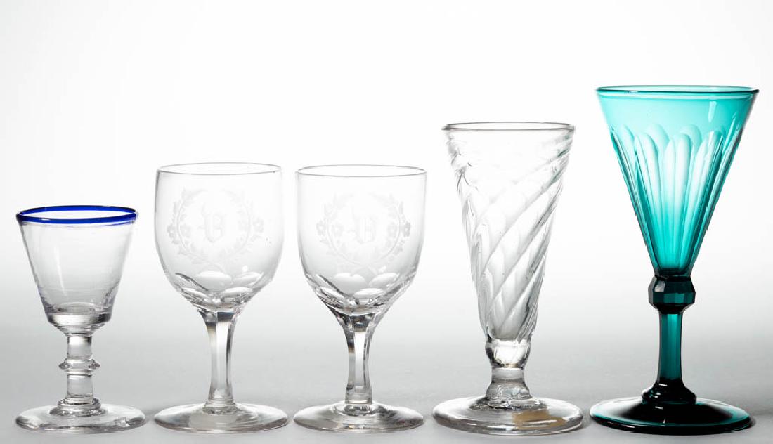 ASSORTED BLOWN DRINKING VESSELS, LOT OF FIVE: ASSORTED BLOWN DRINKING VESSELS, LOT OF FIVE, colorless and emerald green, comprising a cut-fluted wine, a pattern-molded dwarf ale with ribs swirling to the right, a wine with applied blue rim, and a