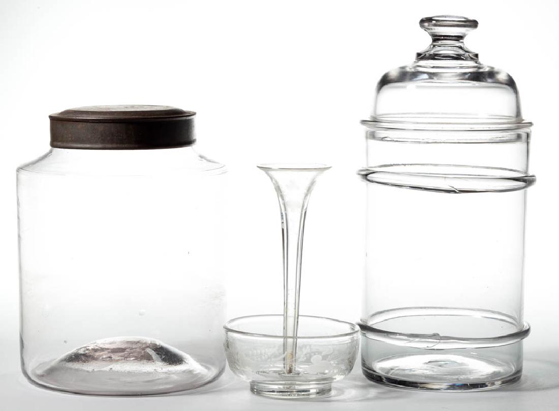 ASSORTED FREE-BLOWN GLASS ARTICLES, LOT OF THREE: ASSORTED FREE-BLOWN GLASS ARTICLES, LOT OF THREE, colorless, comprising a storage jar with a metal lid, an apothecary jar with applied rings and original cover, and a diminutive epergne with engraved 