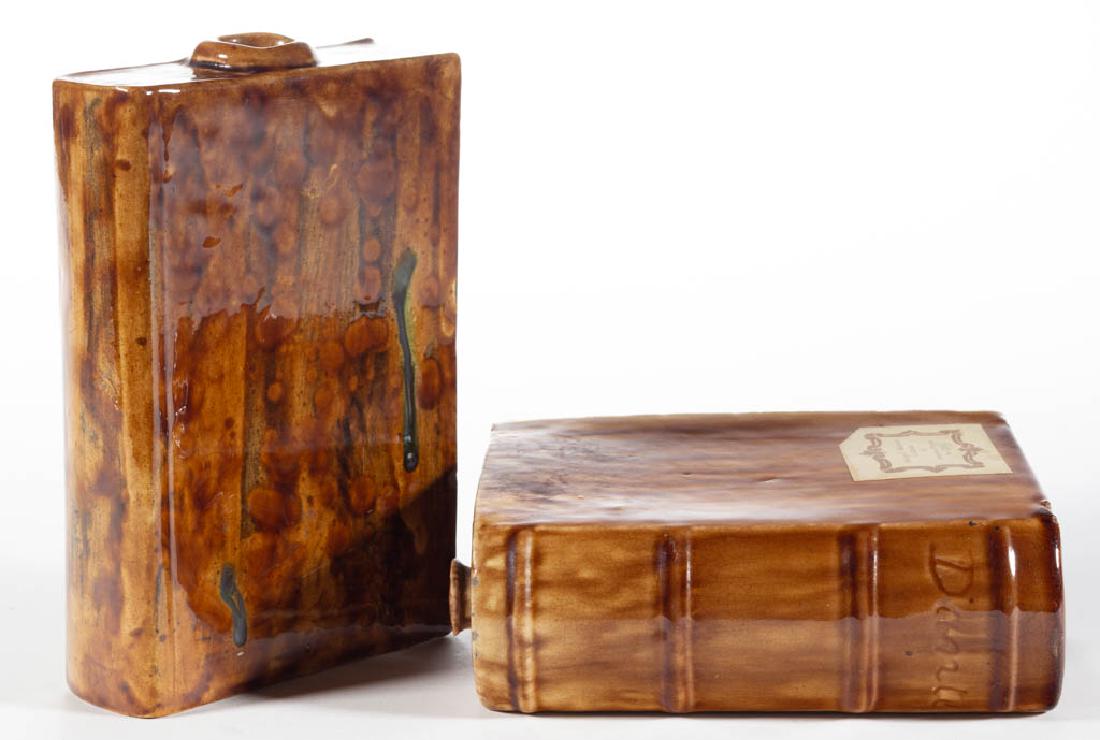 AMERICAN BENNINGTON ATTRIBUTED POTTERY BOOK FLASKS, LOT: AMERICAN BENNINGTON ATTRIBUTED POTTERY BOOK FLASKS, LOT OF TWO, Rockingham-glazed, comprising one having "Dante" incised on spine and one with no title, having a few dark green glaze drips to front, b