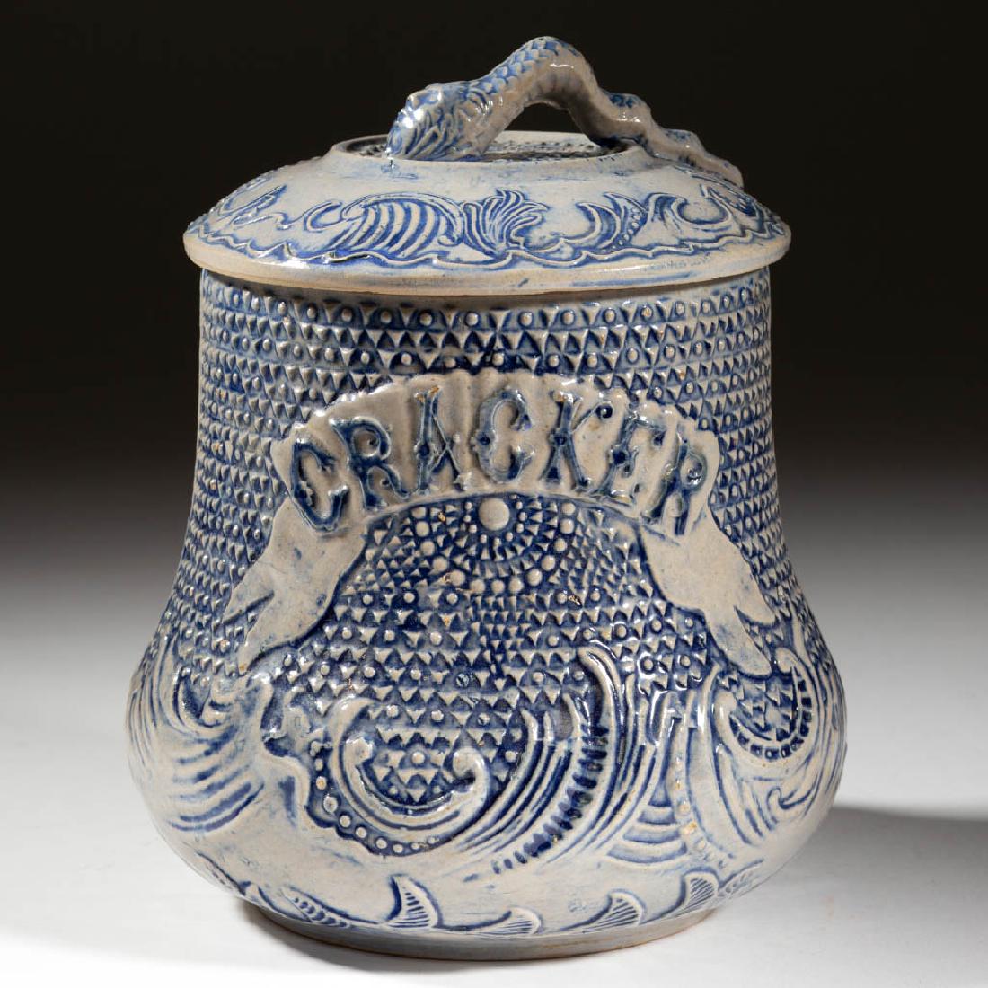 AMERICAN WHITE'S, UTICA, NEW YORK MOLDED STONEWARE: AMERICAN WHITE'S, UTICA, NEW YORK MOLDED STONEWARE COVERED CRACKER JAR, salt-glazed, featuring central "CRACKER" with relief decorations including cobalt wave motif on lower half and cover, having sma