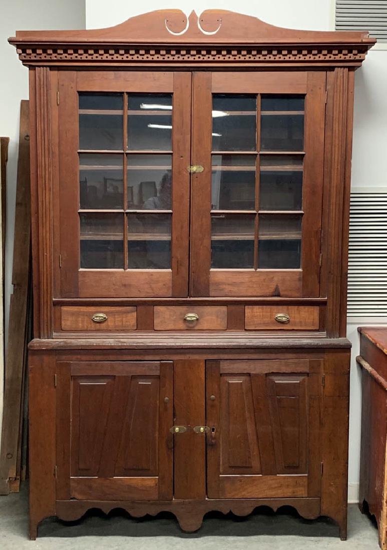 AMERICAN CARVED CHERRY STEPBACK WALL CUPBOARD: AMERICAN CARVED CHERRY STEPBACK WALL CUPBOARD, unique, one-piece construction, cornice with dental molding, above two-hinged doors with six-panes of glass, concealing three shelves, flanked by applied
