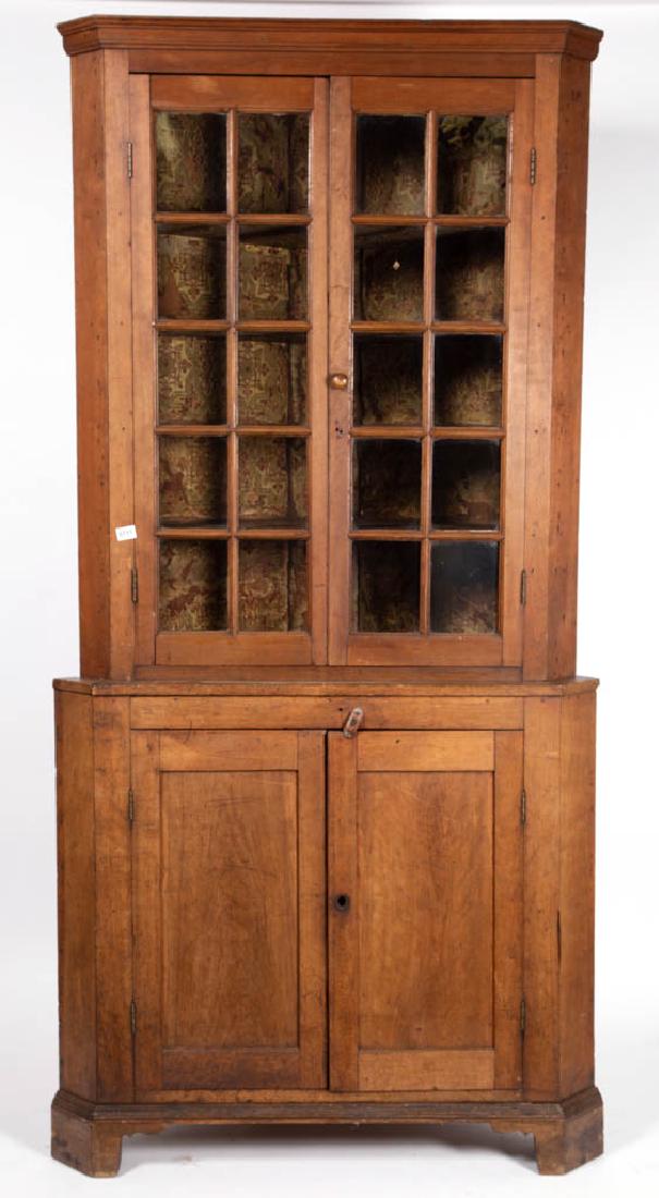 AMERICAN CHERRY CORNER CUPBOARD: AMERICAN CHERRY CORNER CUPBOARD, two-piece construction, upper section applied edge molded cornice, with two-hinged light doors, interior with possibly original wallpaper and four fixed shelves, lower
